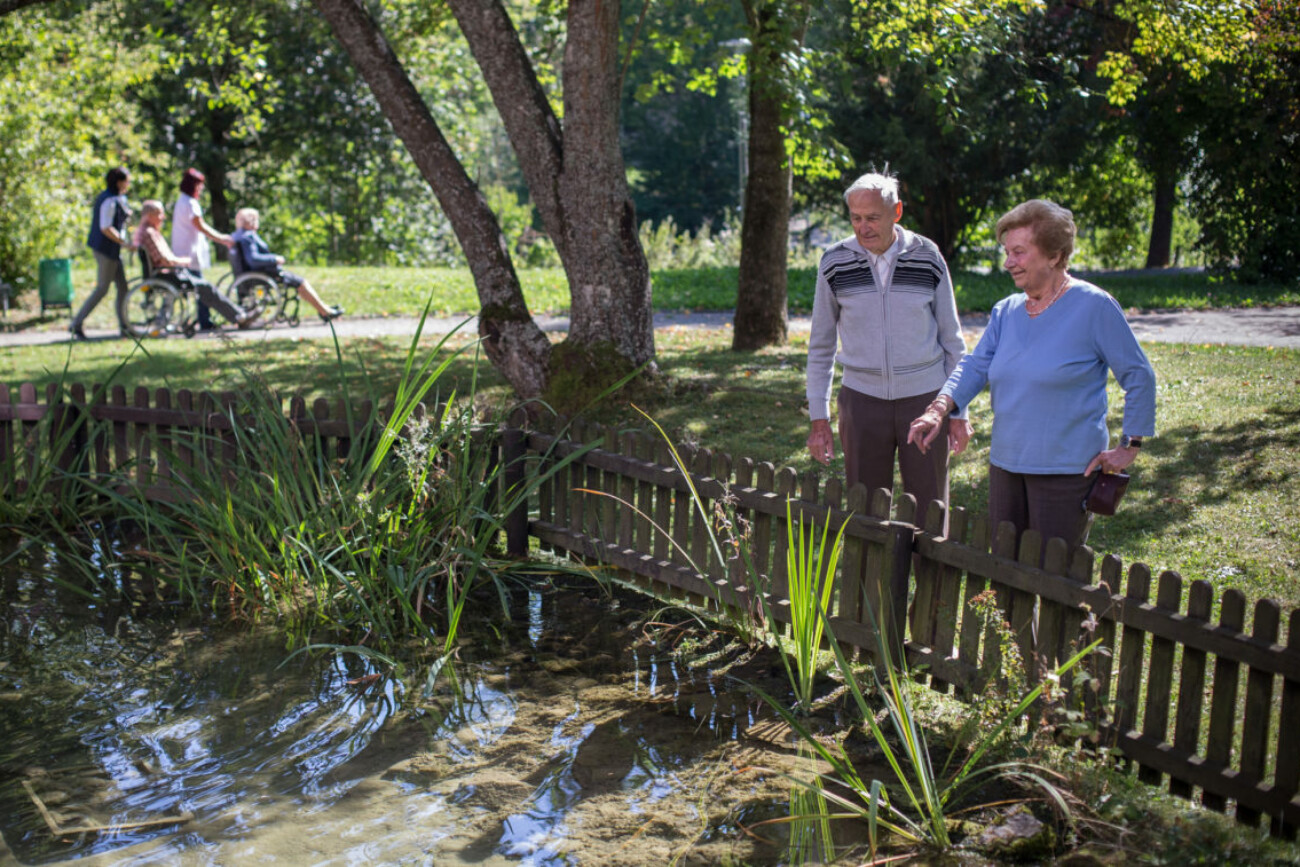 Seniorin mit einem Senior steht am Teich – Lebendiger Alltag im Bürgerheim Schwenningen