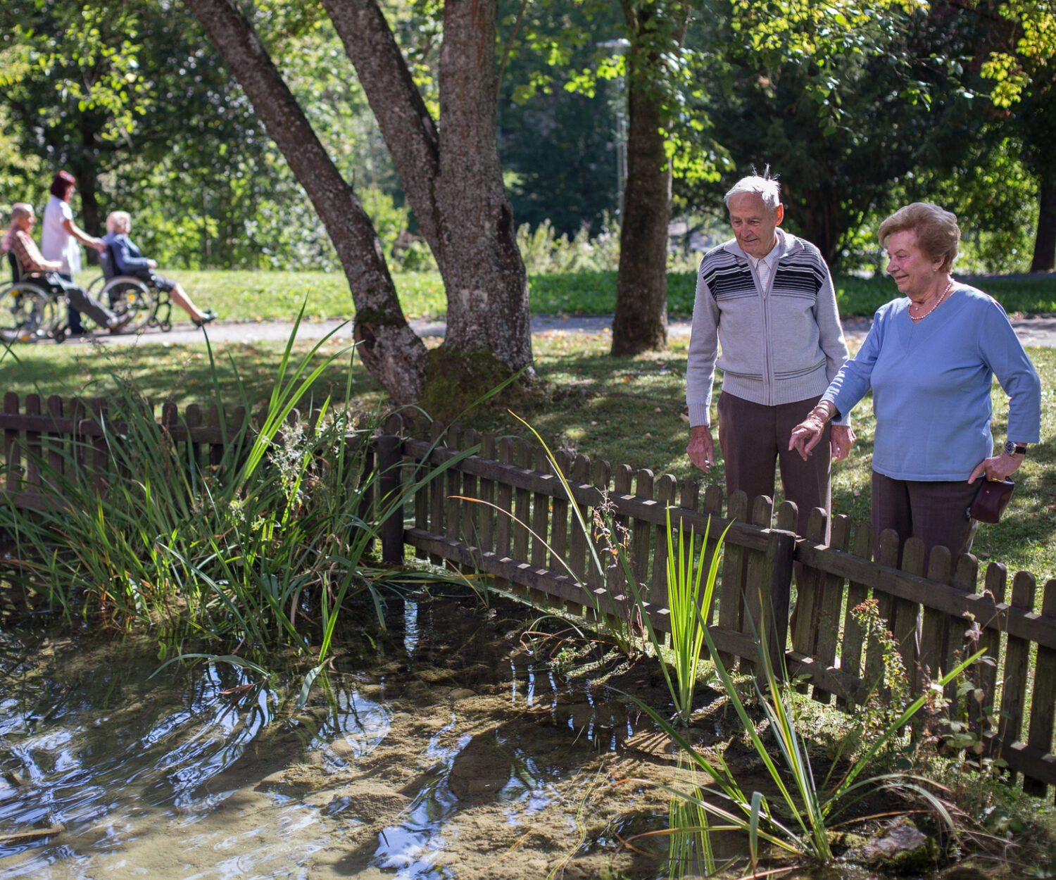 Seniorin mit einem Senior steht am Teich – Lebendiger Alltag im Bürgerheim Schwenningen