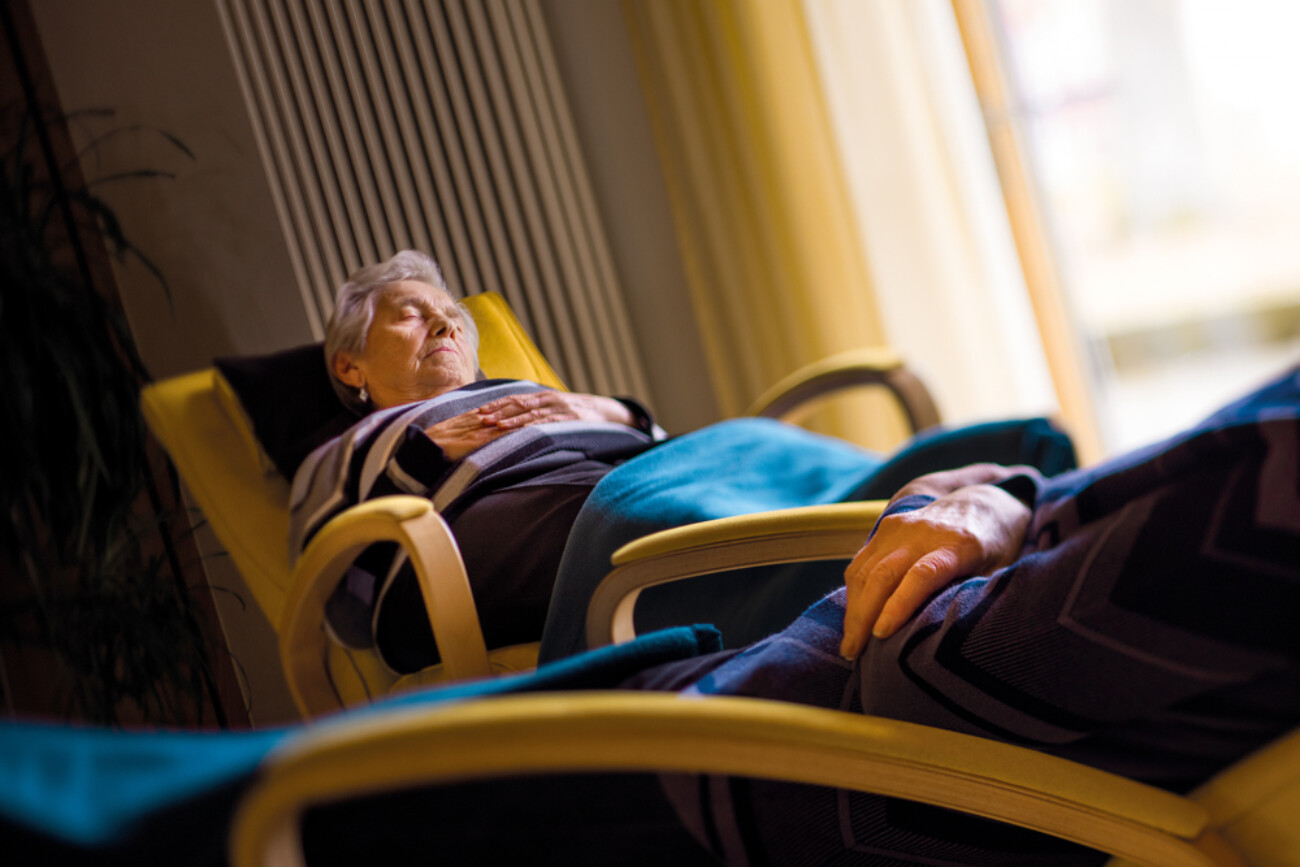 Gemütliche Ruhezeit im Bürgerheim Schwenningen – Bewohnerin entspannt in einem bequemen Sessel mit Blick ins Grüne