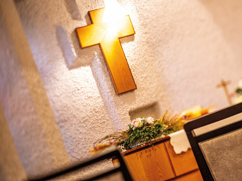 Helle Kapelle im Bürgerheim Schwenningen mit Fenstern, die warmes Licht hereinlassen, und einem einfachen Kreuz
