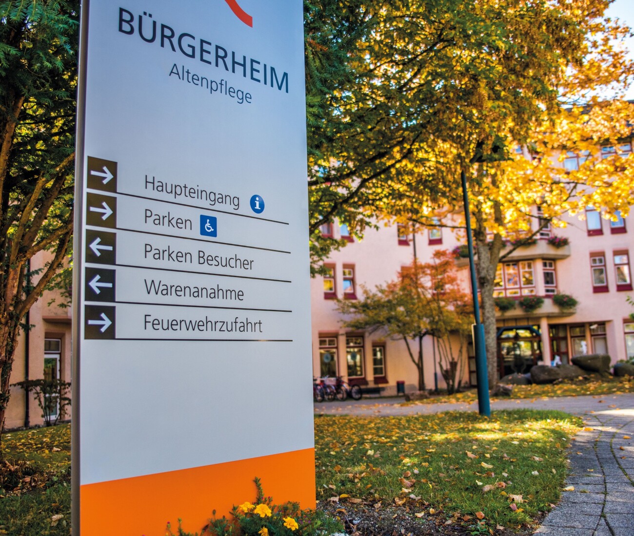 Der Eingangsbereich des Bürgerheims Schwenningen in herbstlichen Farben– Schild und Gebäude mit buntenm Laub
