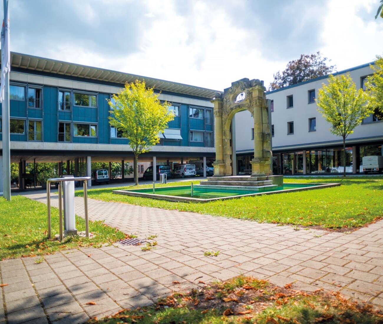 Außenansicht des Bürgerheims Schwenningen im Sommer – gepflegte Gartenanlage mit Brunnen und sonnigem Himmel