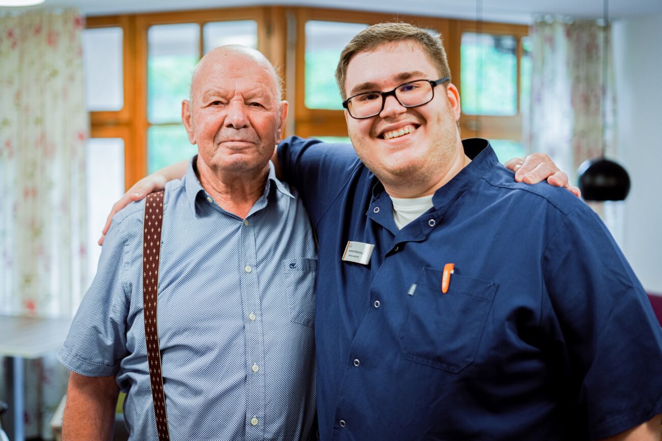 Betreuer im Bürgerheim Villingen-Schwenningen umarmt freundlich einen Senior
