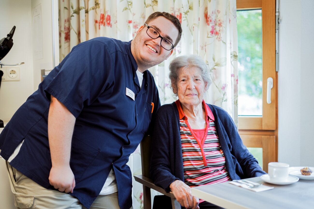 Betreuer im Bürgerheim Villingen-Schwenningen im Gespräch mit einer Seniorin am Tisch bei einer Tasse Kaffee
