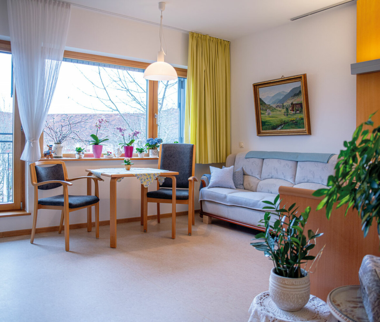Gemütliches, wohnhaftes Zimmer mit Tisch und zwei Stühlen und Sofa.