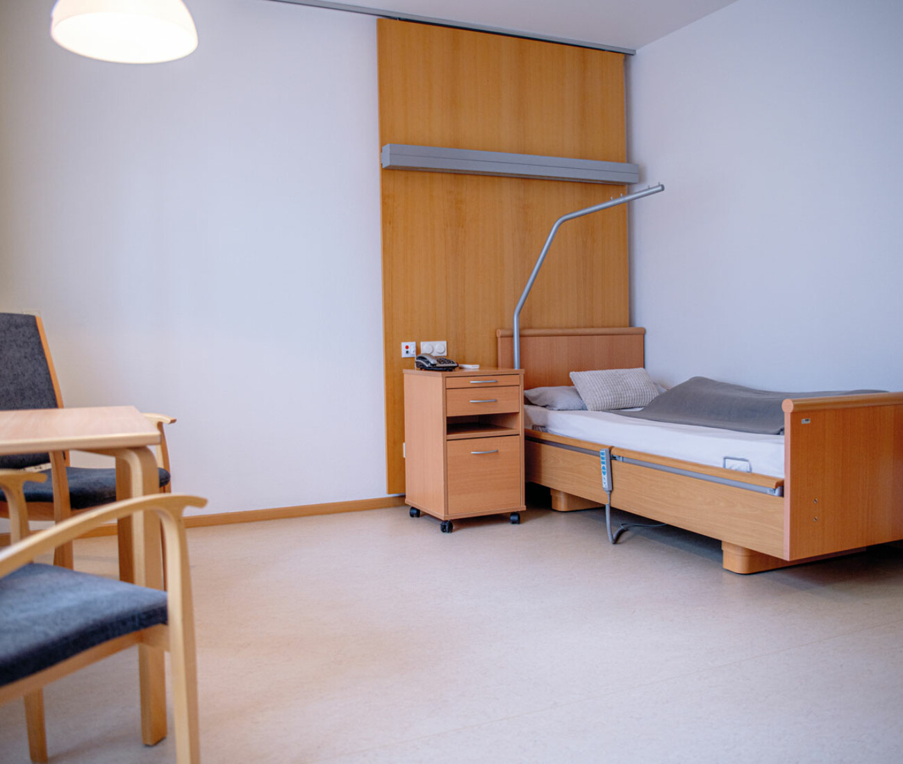 Grundausstattung eines Einzelzimmer im Bürgerheim Schwenningen mit verstellbarem Pflegebett, Nachttisch und freundlicher, heller Einrichtung